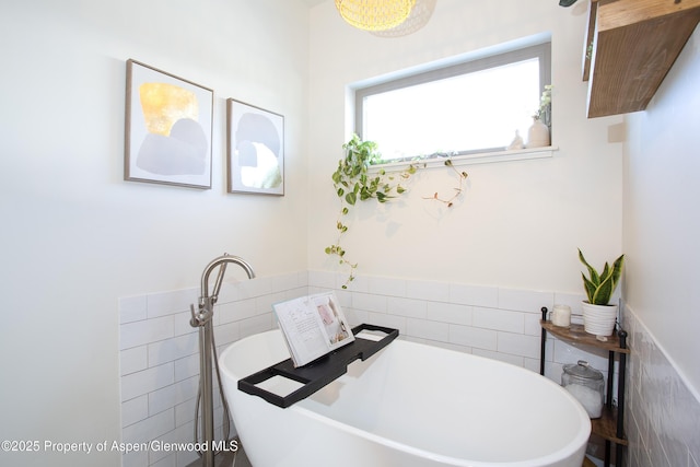 bathroom featuring tile walls and a bath