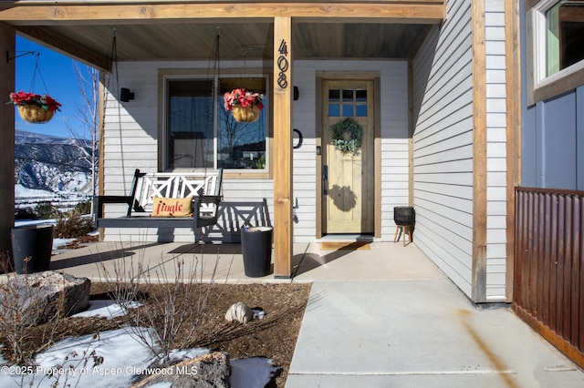 snow covered property entrance with a porch