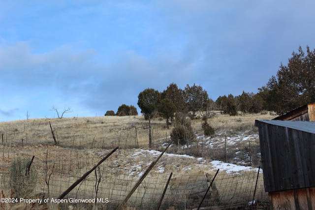 yard covered in snow featuring a rural view