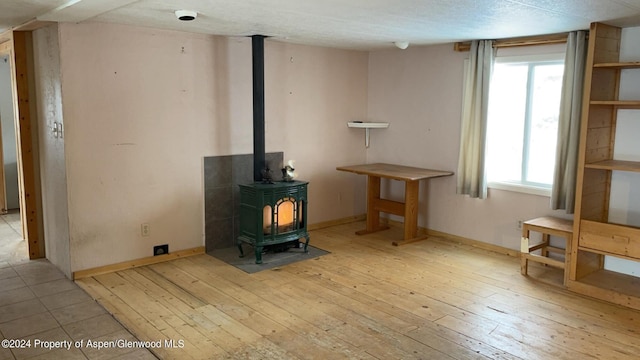 living room with a wood stove, plenty of natural light, and light hardwood / wood-style floors