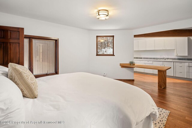 bedroom featuring light wood-type flooring and sink