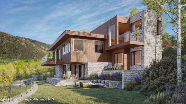 rear view of property featuring a lawn, a mountain view, and a patio