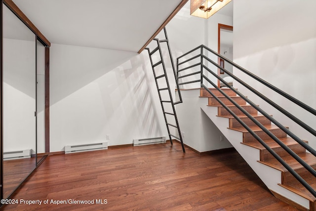 stairs with wood-type flooring and baseboard heating