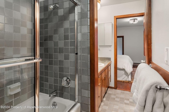 bathroom with combined bath / shower with glass door, vanity, and a baseboard heating unit