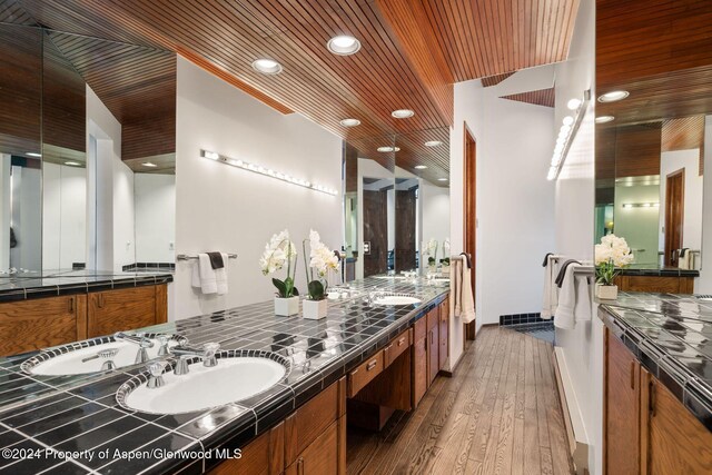 bathroom with hardwood / wood-style floors, vanity, and wood ceiling