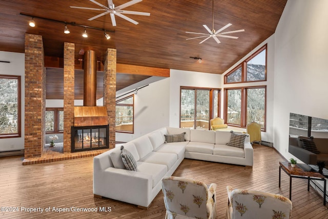 living room with ceiling fan, wood-type flooring, wooden ceiling, and a brick fireplace