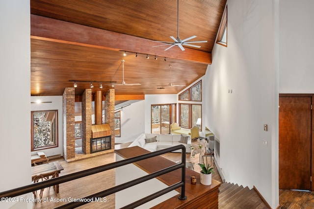 stairs featuring hardwood / wood-style floors, wooden ceiling, lofted ceiling, ceiling fan, and a fireplace