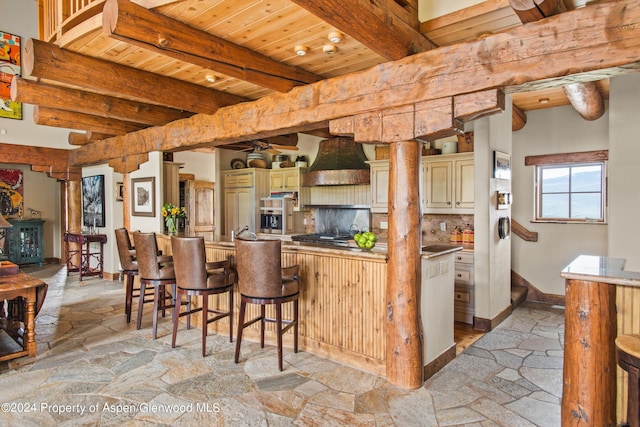 kitchen with beam ceiling, tasteful backsplash, a breakfast bar, wood ceiling, and custom exhaust hood