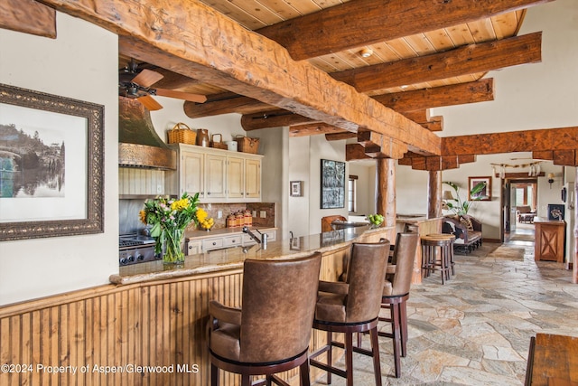 interior space with beamed ceiling, ceiling fan, and wood ceiling