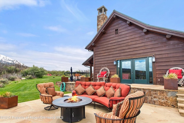 view of patio with french doors and an outdoor living space with a fire pit