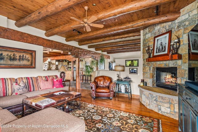 living room with beamed ceiling, hardwood / wood-style flooring, a fireplace, and wood ceiling