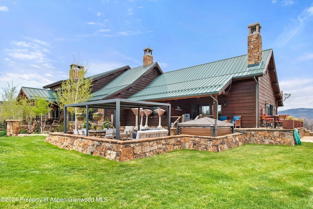 rear view of house with an outdoor hangout area, a yard, a patio, and a hot tub