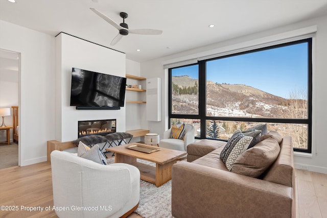 living room featuring light hardwood / wood-style floors and ceiling fan