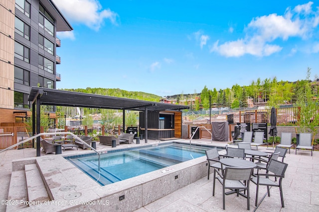 view of pool featuring a hot tub and a patio