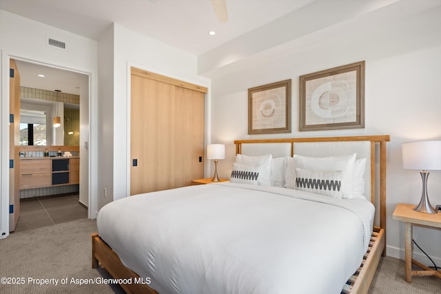 carpeted bedroom featuring connected bathroom and a closet