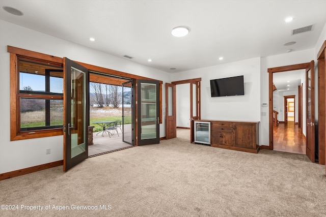 199 Bluestem Ct, Carbondale, CO 81623 - unfurnished living room with wine cooler, light carpet, and french doors