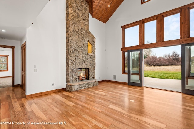 199 Bluestem Ct, Carbondale, CO 81623 - unfurnished living room featuring a stone fireplace, wooden ceiling, light wood-type flooring, and high vaulted ceiling