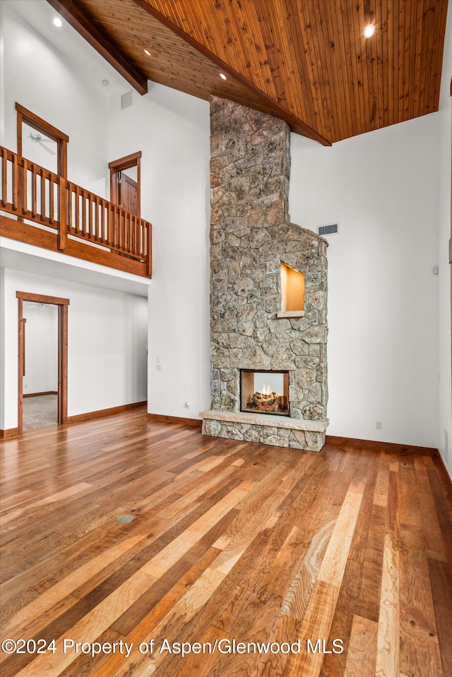 199 Bluestem Ct, Carbondale, CO 81623 - unfurnished living room featuring hardwood / wood-style floors, beam ceiling, a fireplace, and high vaulted ceiling