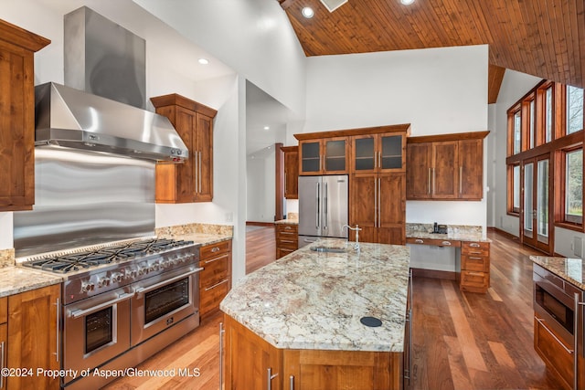 199 Bluestem Ct, Carbondale, CO 81623 - kitchen featuring high end appliances, a kitchen island with sink, high vaulted ceiling, wall chimney range hood, and light stone countertops