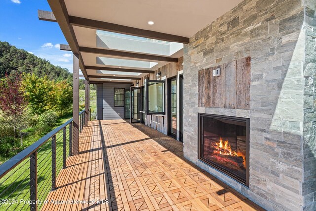 view of patio / terrace with a balcony and exterior fireplace