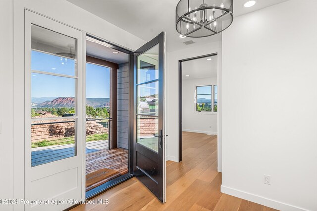 entryway with a mountain view, a chandelier, and light hardwood / wood-style flooring