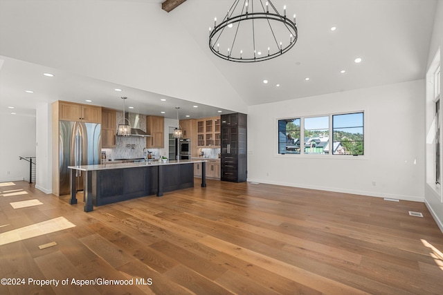 kitchen with a breakfast bar, decorative light fixtures, decorative backsplash, a large island, and stainless steel built in refrigerator