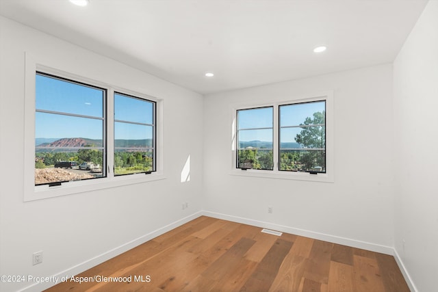 empty room with hardwood / wood-style flooring and a mountain view