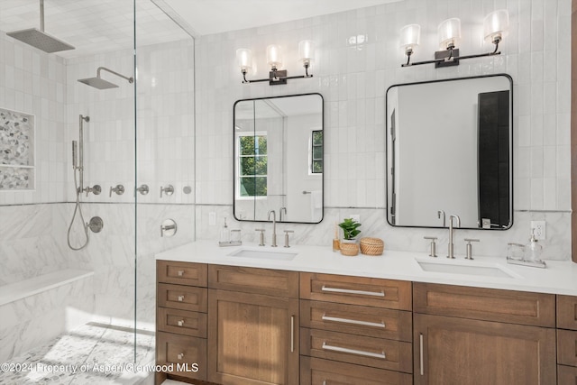 bathroom featuring a tile shower, backsplash, vanity, and tile walls