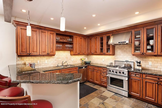 kitchen featuring pendant lighting, wall chimney range hood, sink, appliances with stainless steel finishes, and kitchen peninsula