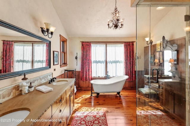 5548 Frying Pan Rd, Basalt, CO 81621 - bathroom featuring lofted ceiling, a chandelier, a freestanding bath, double vanity, and hardwood / wood-style flooring