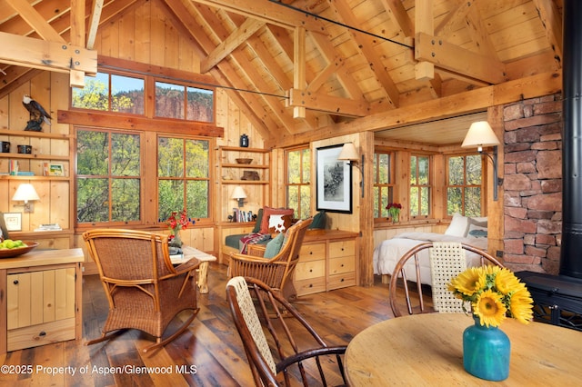 5548 Frying Pan Rd, Basalt, CO 81621 - dining area with a wood stove, a wood ceiling with exposed beams, wood-type flooring, wooden walls, and high vaulted ceiling