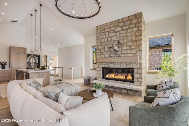 112 Bowles Dr, Carbondale, CO 81623 - living room featuring light wood-style flooring, high vaulted ceiling, a chandelier, a stone fireplace, and recessed lighting