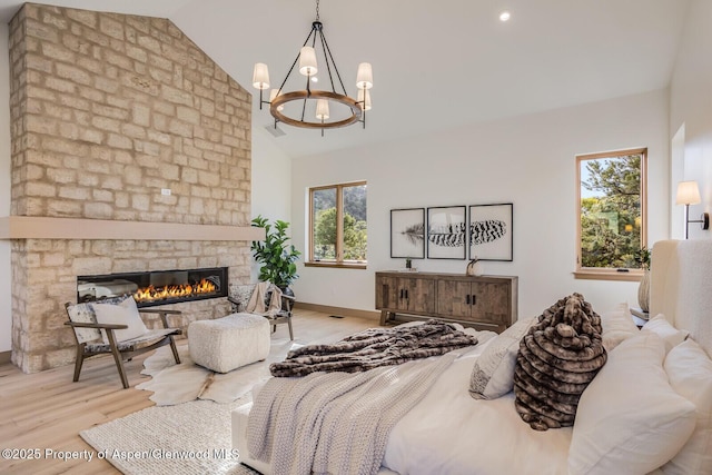 112 Bowles Dr, Carbondale, CO 81623 - bedroom featuring a chandelier, wood finished floors, a large fireplace, high vaulted ceiling, and baseboards
