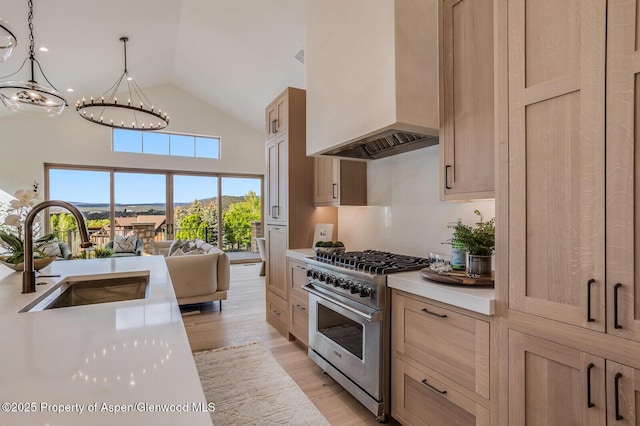 112 Bowles Dr, Carbondale, CO 81623 - kitchen with high end stove, a sink, custom range hood, light countertops, and a chandelier