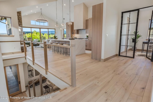 112 Bowles Dr, Carbondale, CO 81623 - kitchen featuring light wood-style flooring, high vaulted ceiling, a center island with sink, recessed lighting, and hanging light fixtures
