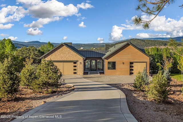 112 Bowles Dr, Carbondale, CO 81623 - view of front facade with a garage, a standing seam roof, a mountain view, concrete driveway, and metal roof