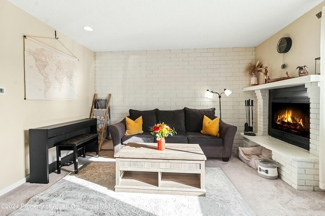 carpeted living room featuring brick wall and a brick fireplace