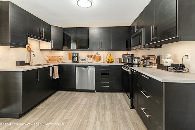 kitchen featuring sink, light wood-type flooring, and appliances with stainless steel finishes