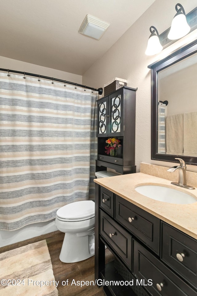 bathroom with hardwood / wood-style flooring, vanity, and toilet