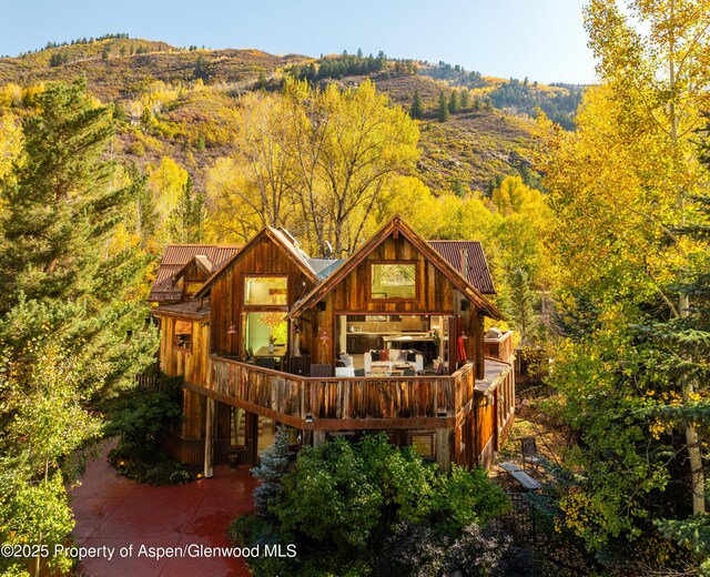 71 Smuggler Grv, Aspen, CO 81611 - rear view of property with a wooden deck and a view of trees