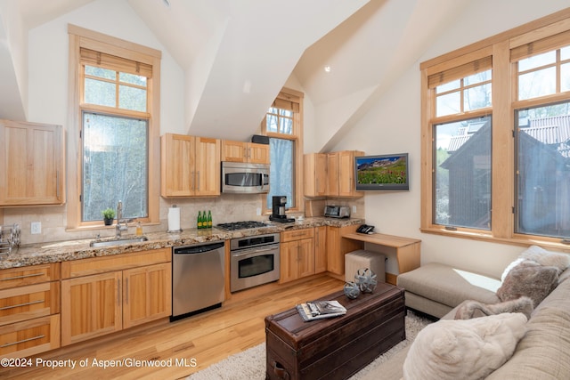 71 Smuggler Grv, Aspen, CO 81611 - kitchen with stainless steel appliances, light brown cabinets, a sink, and high vaulted ceiling