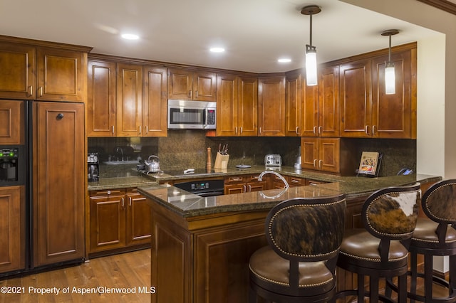 0197 Prospector Rd Unit 2412Summer Interest, Aspen, CO 81611 - kitchen with black appliances, dark stone countertops, decorative backsplash, a breakfast bar, and recessed lighting