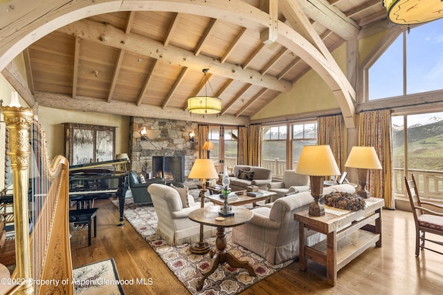 800 Chateau Way, Snowmass, CO 81654 - living room featuring a stone fireplace, beamed ceiling, high vaulted ceiling, wood-type flooring, and wood ceiling