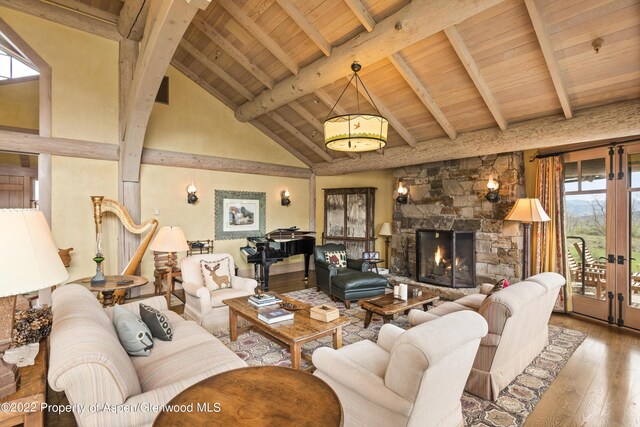 800 Chateau Way, Snowmass, CO 81654 - living room featuring beamed ceiling, a stone fireplace, wood-type flooring, and high vaulted ceiling