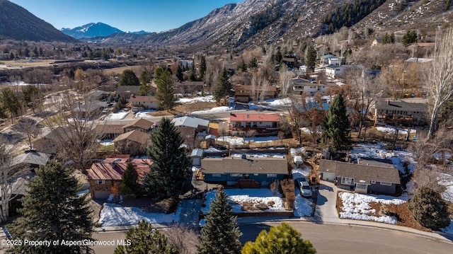 snowy aerial view featuring a residential view and a mountain view