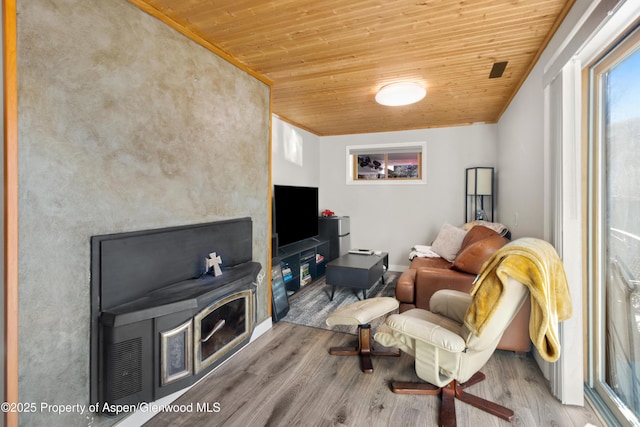 living room featuring wood ceiling, crown molding, and wood finished floors