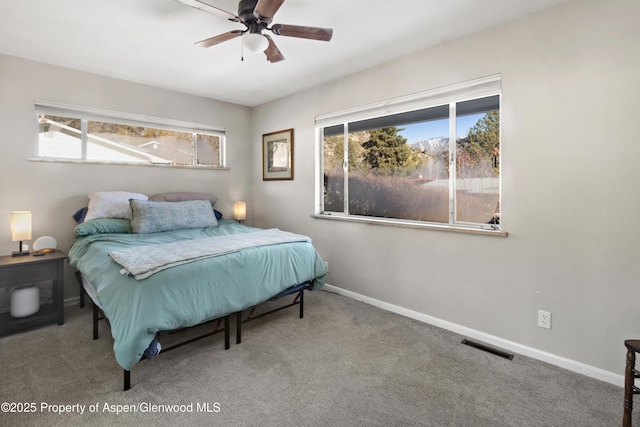 carpeted bedroom with a ceiling fan, visible vents, and baseboards