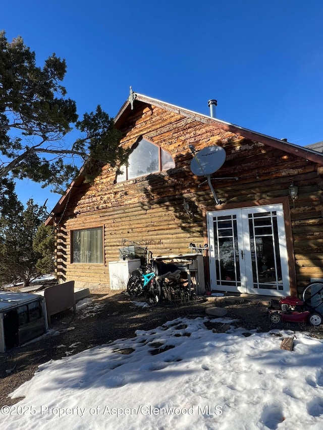 snow covered property with french doors