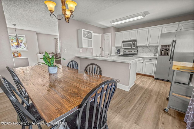 830 Exmoor Rd, Craig, CO 81625 - dining room with a chandelier, light wood-style floors, and a textured ceiling