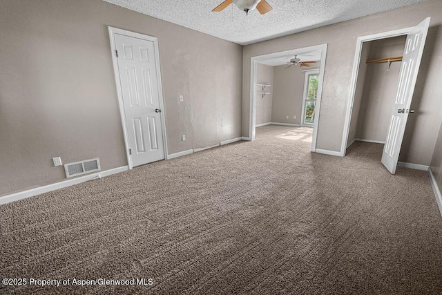 830 Exmoor Rd, Craig, CO 81625 - unfurnished bedroom featuring carpet, a textured ceiling, a ceiling fan, and two closets